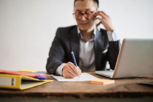 Small business owner answering a customer phone call at a desk